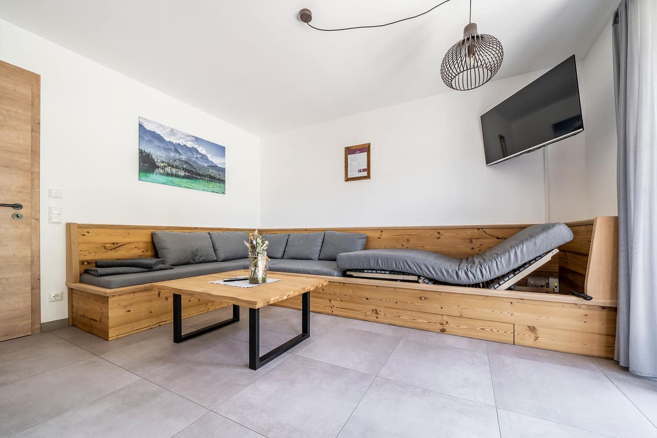 Alpenrose Lenggries Ferienwohnung im Erdgeschoss - Wohnraum mit Schlafcouch (höhenverstellbarer Lattenrost)